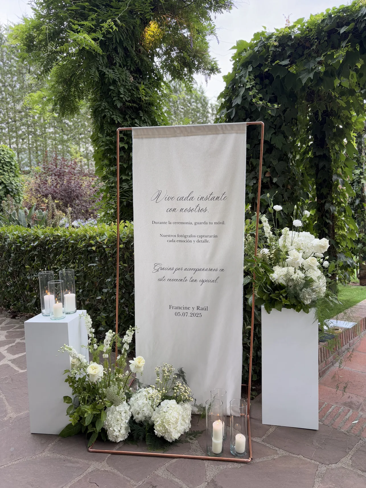 Cartel de bienvenida en tela con flores blancas para una boda