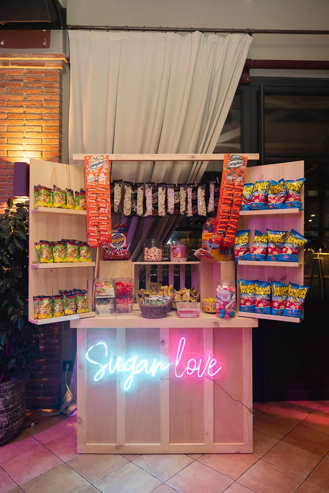 Candy bar personalizado con dulces, decoración y letrero luminoso